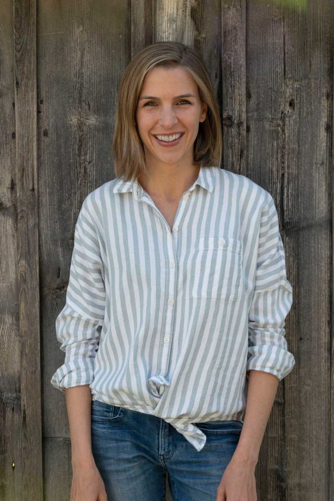 Portrait von Daniela Daroussis vor einer Holzwand.